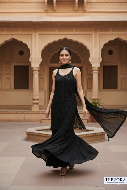 Woman in a black dress standing in front of an architectural building
